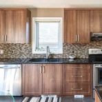 Kitchen with brown cabinets and black counter tops